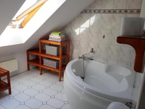 a bathroom with a white tub in a attic at Apartament Centrum - Giżycko in Giżycko