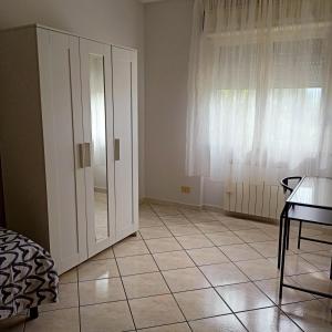 a room with a white cabinet and a tiled floor at B&B Bella Notte in Montesilvano