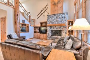 a living room with leather furniture and a stone fireplace at Aquila Lodge - Unit 5 in Sunriver