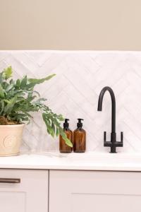 a kitchen sink with two bottles of soap at Hailes - a newly converted barn on our farm between Stratford upon Avon and the Cotswolds in Evesham