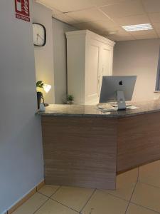biuro z biurkiem z laptopem na ladzie w obiekcie HOSTEL Cangas w mieście Cangas de Morrazo