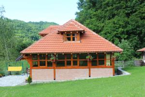 a small house with a red roof on a field at Tićin vajat in Valjevo