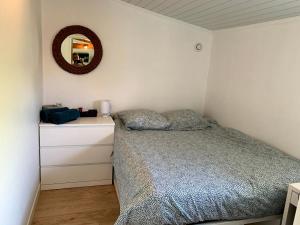 - une chambre avec un lit et un miroir mural dans l'établissement Cottage des vignes, à Pessac