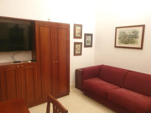 - un salon avec un canapé rouge et une télévision dans l'établissement La Dimora dei Reali, à Naples