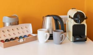 un bancone della cucina con macchinetta del caffè e tazze di B&B Gösselsdorfer Seeblick a Sittersdorf