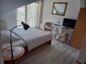 a bedroom with a bed and a desk with a computer at Villa Osowianka in Gdańsk
