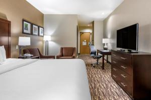 a hotel room with a bed and a flat screen tv at Comfort Suites Portland Airport in Portland