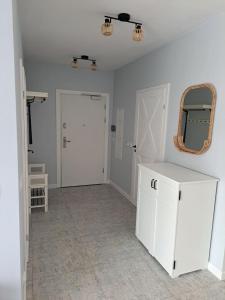 a room with a white cabinet and a mirror at Willa la Maddalena apartament in Unieście +7 photos