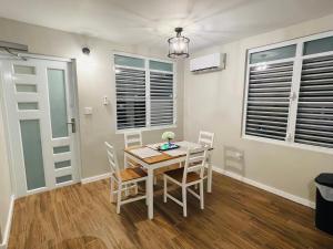a dining room with a table and chairs and windows at Home for your stay in Humacao
