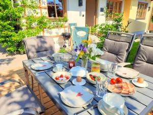 una mesa azul con platos y tazones de comida. en 103 m2 Apartment EschenWald vomLandl Leogang, en Leogang