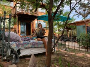a woman sitting on a bed under an umbrella at Mystic Portal 420 Guesthouse in Colorado Springs