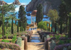 un jardin avec un chemin menant à un kiosque dans l'établissement Apto. Jardín de Santa Bárbara, à Blanes