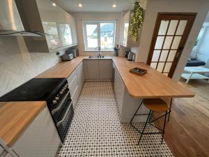 a kitchen with a wooden counter top and a table at 1min walk to Beach- Happy Waves- Family Home in Camber +17 photos