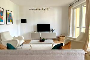 ein Wohnzimmer mit einem Sofa und einem TV in der Unterkunft Family friendly Work from Home 2BR, Balcony, Wifi, Netflix, Near BASF in Ludwigshafen am Rhein