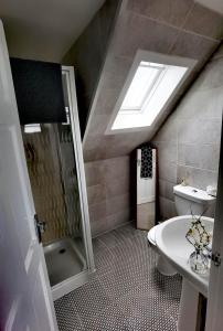 La salle de bains est pourvue d'une douche, de toilettes et d'un lavabo. dans l'établissement Cozy Loft In The Heart Of Kirkwall, à Orkney
