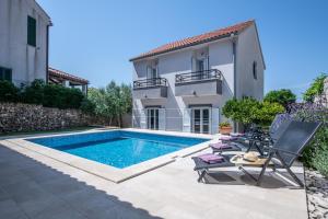 a villa with a swimming pool and a house at Villa Mediterana in Vis