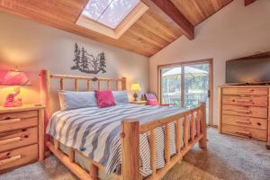 a bedroom with a wooden bed and a television at Tan Oak - Unit 37 in Sunriver +41 photos