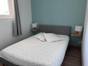 een bed in een slaapkamer met 2 nachtkastjes bij Appartement avec Sauna et Piscine au bord de mer in Plougonvelin