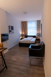 Hotel Berliner Hof في رمشيد: غرفة نوم بسرير واريكة في غرفة