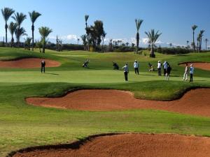 a group of people playing golf on a golf course at Prestigia Agate 260 in Marrakesh