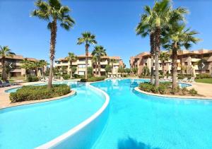 a large swimming pool with palm trees in a resort at Prestigia Agate 260 in Marrakesh