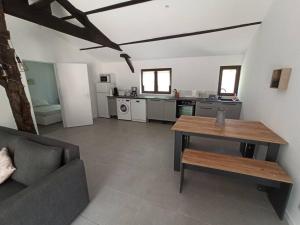 ein Wohnzimmer mit einem Tisch und einer Küche in der Unterkunft Magnifique pigeonnier rénové classé 3 étoiles in Catus