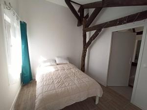 Schlafzimmer mit einem Bett und Holzbalken in der Unterkunft Magnifique pigeonnier rénové classé 3 étoiles in Catus