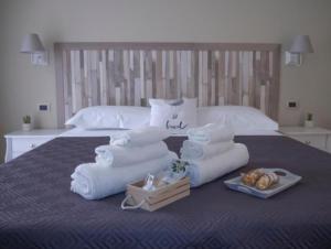 a pile of towels and bread on a bed at Viaggio in Sicilia B&B in Gravina di Catania