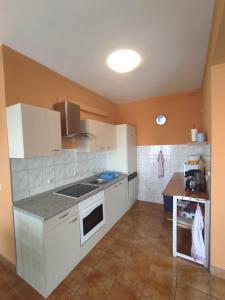 une cuisine avec des placards blancs et un comptoir dans l'établissement Apartman Mila, à Novi Vinodolski