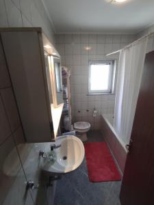 a bathroom with a sink and a toilet and a window at Apartman Mila in Novi Vinodolski