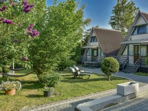 a house with a yard with a bench and flowers at Holiday homes, Kolobrzeg in Kołobrzeg