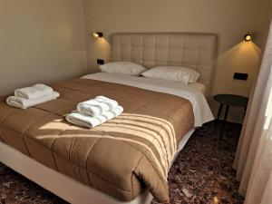 Un dormitorio con una cama grande con toallas. en Mosaic Apartments, en La Canea