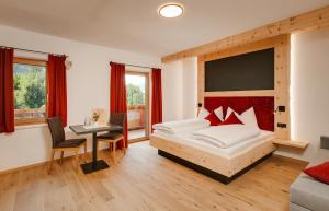 Schlafzimmer mit einem Bett und einem Schreibtisch mit einem Tisch in der Unterkunft Edenhauserhof in Innsbruck