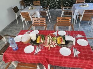 a table with plates of food on a red table cloth at Agropensiunea Pe Poderei in Cupşeni