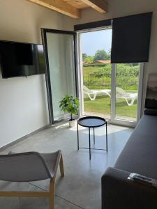 een woonkamer met een bank, een tafel en een raam bij Apartamentos Aronces in Cudillero