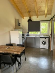 uma cozinha com uma mesa, um lavatório e um fogão em Apartamentos Aronces em Cudillero