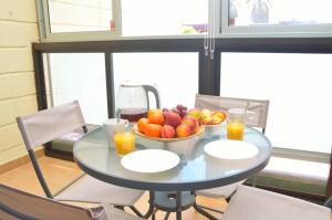 a table with a bowl of fruit and two glasses of orange juice at CALO BEACH in Costa Del Silencio