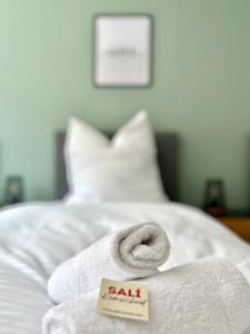 biały ręcznik na łóżku ze znakiem asale w obiekcie Sali - R2 - Apartmenthaus, WLAN, TV w mieście Remscheid