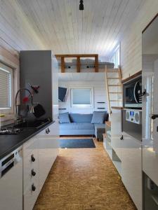 cocina y sala de estar con sofá en una casa pequeña en TinyHouse am Naturteich - Nähe Sächsische Schweiz, Dresden, en Großharthau