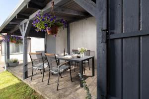 een patio met een tafel en stoelen en een pot bloemen bij Apartman Beli in Vinkovci