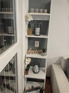 una habitación con un estante con plantas y un sofá en Apartment Victoria, en Split