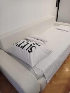 Una cama blanca con una almohada con la palabra "ayuda" en Apartment Victoria, en Split