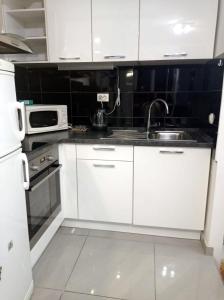 cocina blanca con fregadero y microondas en Apartment Victoria, en Split