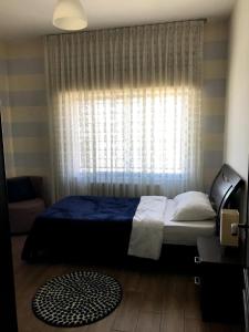a bedroom with a bed and a window at Superb 2 Bed in middle of Amman in Amman