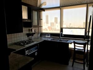 a kitchen with a sink and a stove and a window at Superb 2 Bed in middle of Amman in Amman