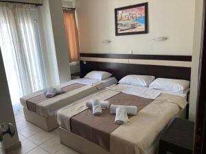 two beds in a hotel room with towels on them at VILLA HARIKLIA in Paralia Katerinis
