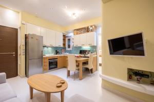 a kitchen and dining room with a table and a tv at Corfu Dream Home in Corfu Town