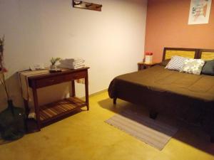 a bedroom with a bed and a nightstand with a table at Crisol. in Cafayate