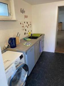 uma cozinha com uma máquina de lavar roupa e um lavatório em Gemütliches Apartment für Monteure em Recklinghausen