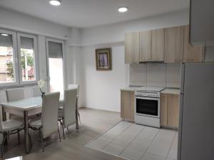 a kitchen and dining room with a table and chairs at Apartment Matej in Skopje +11 photos